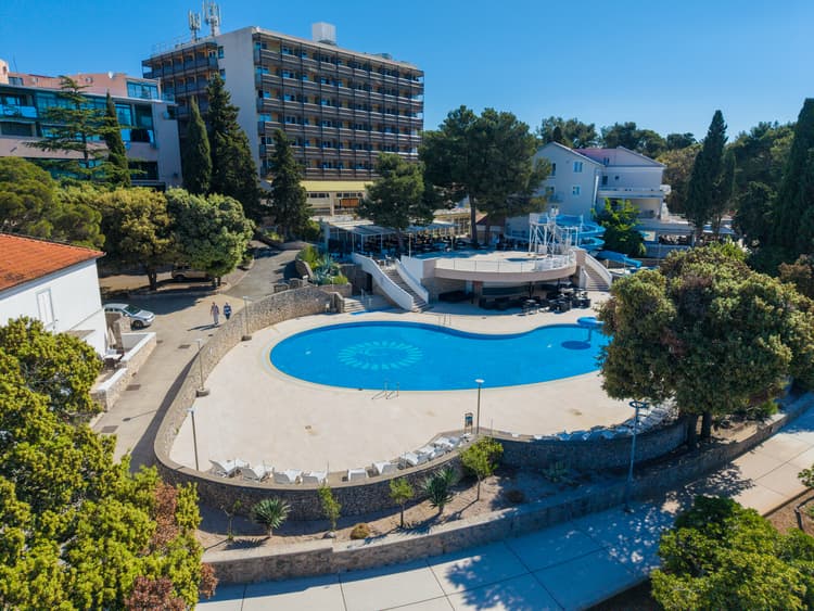 Aerial view of Dražica Hotel Resort on Krk island, with an outdoor swimming pool and surrounding greenery