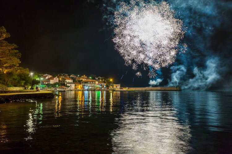 Vatromet iznad obale grada Krka noću, uz osvijetljenu rivu i more