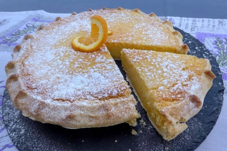 Presnac-Dessert serviert mit Puderzucker und einer Orangenscheibe